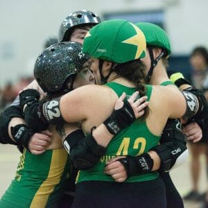 roller derby teammates embrace at a Swamp City Sirens bout