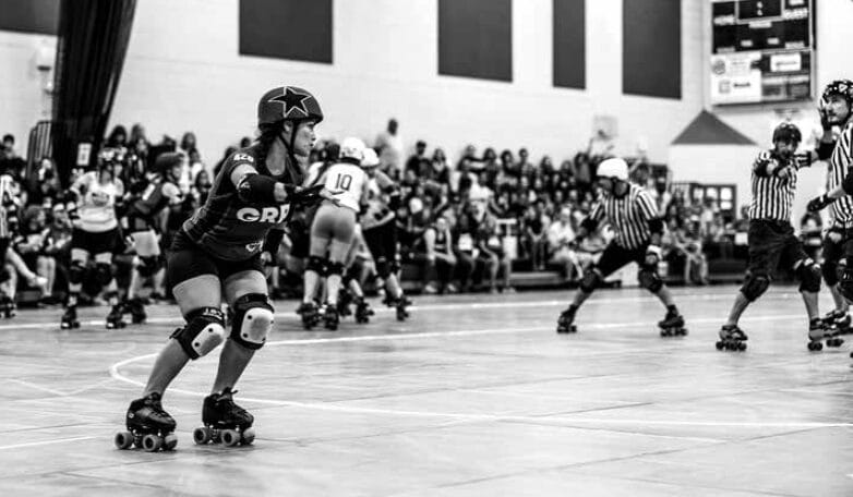 Black and white photo of the Gainesville Roller Rebels skating in a bout